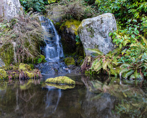 Japanese garden waterfall with rocks and moss rocks