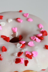 Obraz na płótnie Canvas close up of glazed donut with heart shaped sprinkles