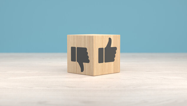 Wooden cube with thumbs up and thumbs down symbols