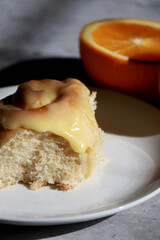 close up of orange cinnamon rolls, with oranges in background
