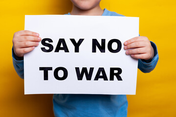 little boy, child with Ukrainian flag on cheeck isolated yellow background. Say no to war. Support...