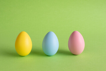 Easter eggs on green background. Yellow, blue and pink easter eggs.