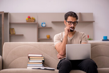 Young male student studying at home during pandemic