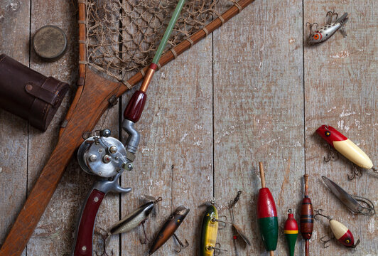 Antique fishing rod with lures net and bobbers on grunge wood surface Stock  Photo