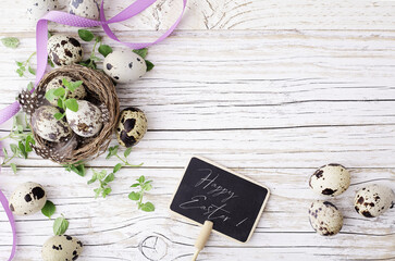 easter quail eggs and flowers on wooden background. copy space for text