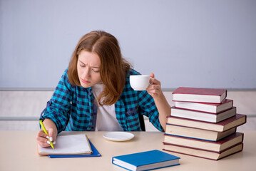 Young female student drinking coffee during break