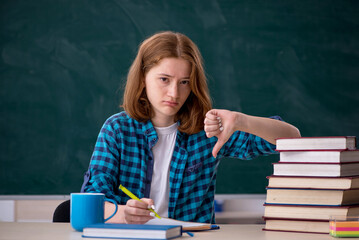 Young female student preparing for exams in the classroom