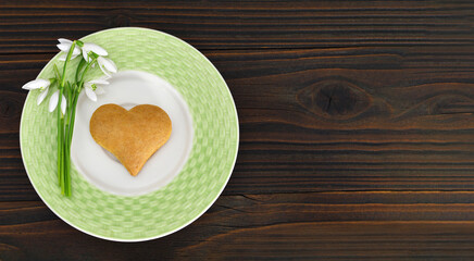 Mothers day heart shaped cookie and snowdrops on the plate