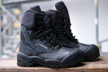 close-up of pair of new black work boots made of leather with reinforced cape, high top on...