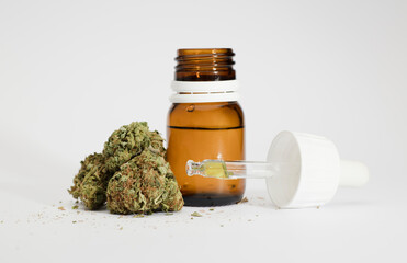 set of marijuana buds, with dispenser bottle, white background.
