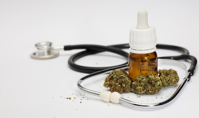 set of marijuana buds, with dosing bottle, stethoscope, white background.