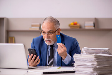 Fototapeta premium Old male boss working from home during pandemic