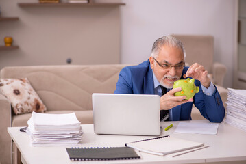 Old male boss working from home in retirement concept