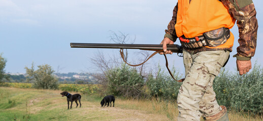 Hunter man in camouflage with a gun during the hunt in search of wild birds or game. Autumn hunting...