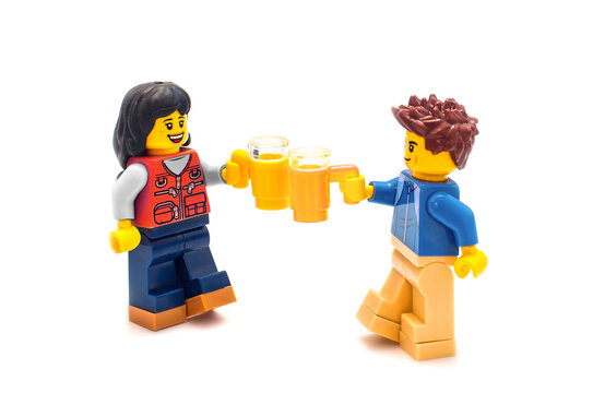 2022:  Lego toy personages on white, couple with beer mugs. russian-ukrainians people concept