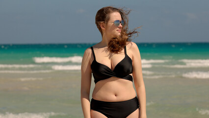 Young pretty woman wearing a bikini at Miami Beach on a windy day