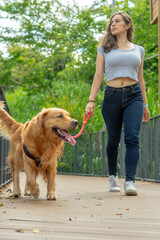 girl in park casual jeans uncomplicated art dog pet animal canine golden retriver 
walking dog