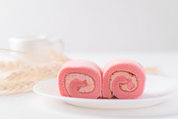 Pink strawberry roll cake or swiss roll with whipped cream and strawberry flavor on white background