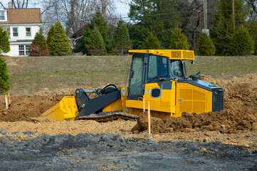 Excavator at building under construction backhoe digs the ground for the foundation and for laying...