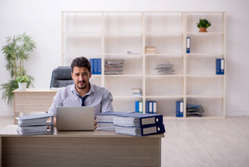 Young male employee and too much work in the office