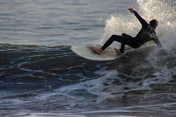 Surfing Rincon point in California in the winter at sunset