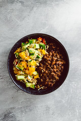 vegan mexican bowl with spicy bean mix and bell pepper cucumber salad, healthy plant-based food