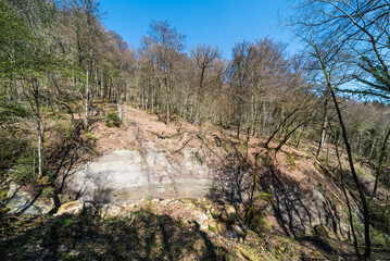 Valley of the Aesenbach creek filled with rocks and surrounded by bare spring trees around Echternach, The Grand Duchy of Luxembourg
