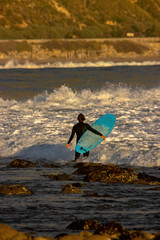 Surfing Rincon point in California in the winter at sunset