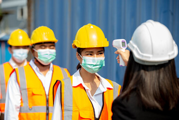 Checking the body temperature of workers by a thermometer.