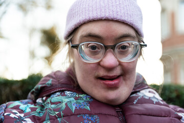Outdoor portrait of a 39 year old white woman with the Down Syndrome wearing a blue bike helmet