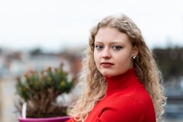 Outdoor beauty portrait of a 21 year old white blonde woman with curling hair