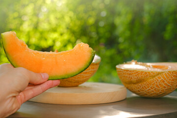 Melon.piece of ripe melon.Melon in a cut in female hands. Appetizing summer fruits. Women's hands cut a ripe melon