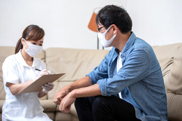 Obraz premium 問診票に記入する看護師と患者（マスクと手袋）