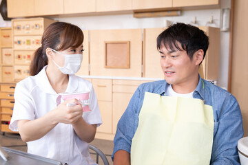 歯磨き指導をする歯科衛生士と男性患者
