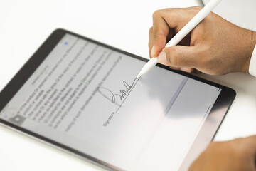 Close up businessman hand electronic Signature on Tablet by Stylus. Write business agreement of...