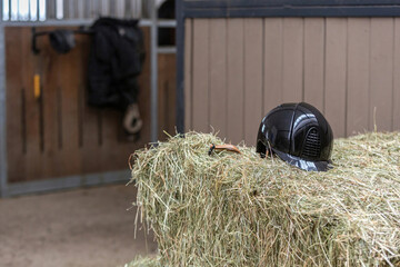 Equestrian scene: A riding helmet on a hay bale