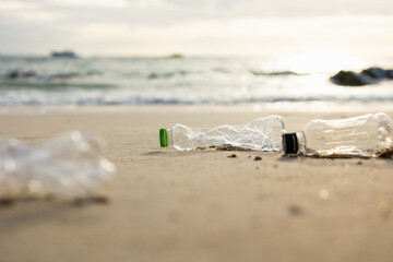 Plastic water bottles are left on the beach as waste polluting nature. Plastic is hard to degrade. destroy the ecosystem. World environment day concept.