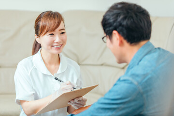 Obraz premium 問診する看護師と男性患者 