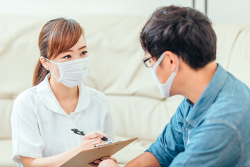 Obraz premium 問診する看護師と男性患者 