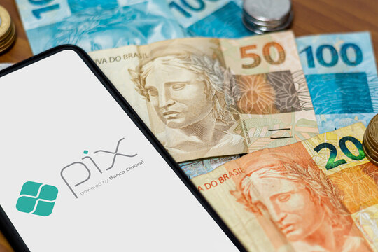 Sao Paulo, Brazil. MARCH 8, 2022: Pix logo on smartphone screen with multiple coins around. Pix is the new payment and transfer system of the Brazilian and Brazilian government.