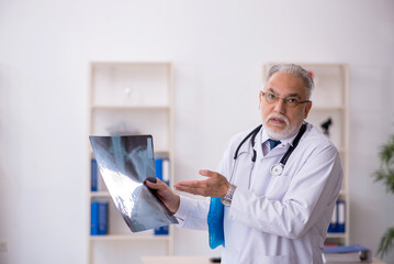 Old male doctor radiologist working in the clinic