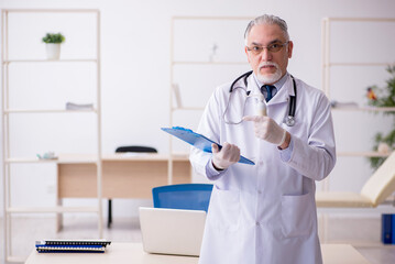 Old male doctor working in the clinic