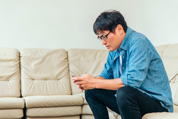 Fototapeta premium 待合室のソファに座る男性患者 