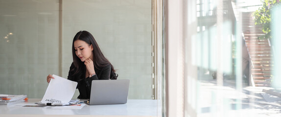 Crop shot of business asian woman investment consultant analyzing company annual financial report balance sheet statement working with documents graphs. Concept picture of business, market, tax.