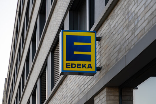 DRESDEN, GERMANY - 08. March 2022: Edeka supermarket company logo on a facade of a building. Sign of a big German retailer outdoors. Advertisement emblem of a groceries store.