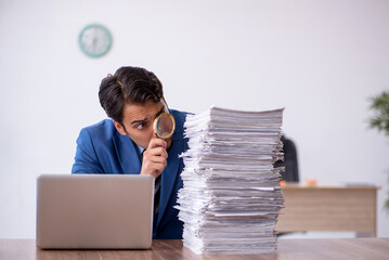 Young male employee unhappy with excessive work in the office