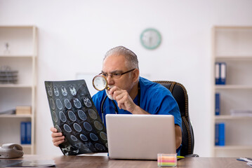 Old male doctor radiologist working in the clinic