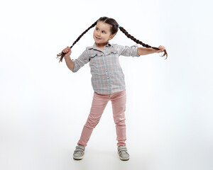charming little girl with braided pigtails in the studio on a white background.