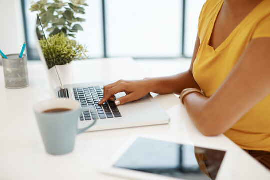 Handling Her Business Like A True Go Getter. Cropped Shot Of A Businesswoman Using A Laptop At Her Desk In A Modern Office.