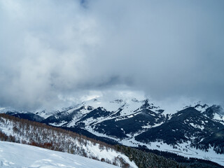 The image of the ski slopes covered by snow clouds.